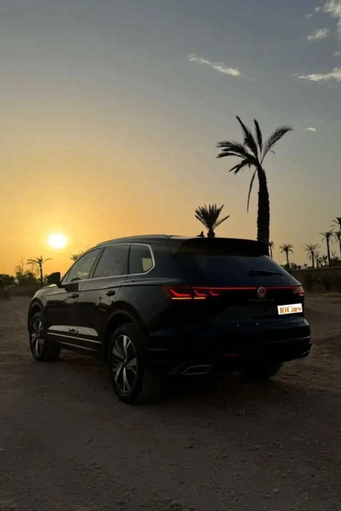 Volkswagen Touareg rental in Morocco by 16Cars, luxury black SUV parked at sunset with palm trees in the background